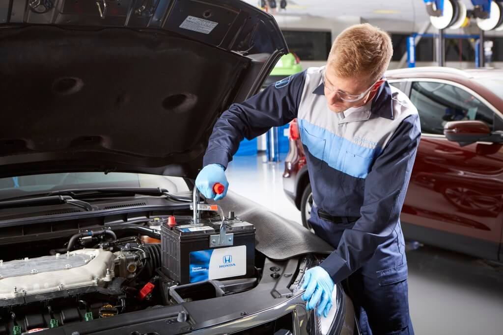 image of a technician servicing a car battery